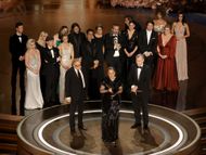 Christopher Nolan with the cast and crew of Oppenheimer, accepting the Best Picture Oscar (Image via Getty)